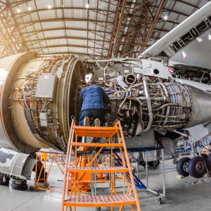 How an Aerospace Contract Manufacturer Ensures Safety Standards - Specialist mechanic repairs the maintenance of a large engine of a passenger aircraft in a hangar