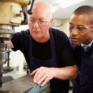 Engineer Teaching Apprentice To Use Precision Mill Turning